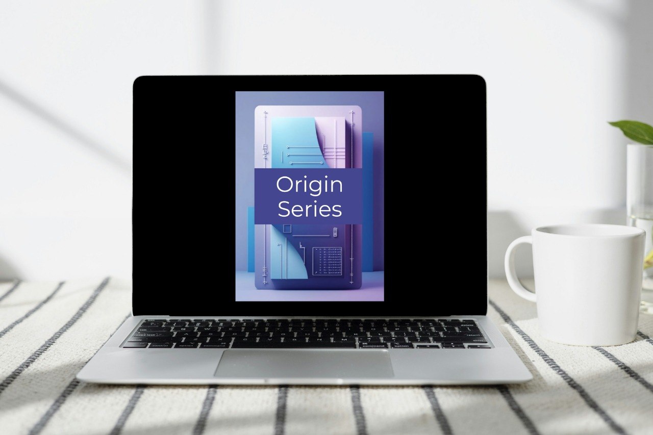 A silver laptop sits open on a striped fabric surface, displaying a book or booklet cover titled "Origin Series" in a blue and purple design. A white mug is visible to the right in a bright indoor setting.